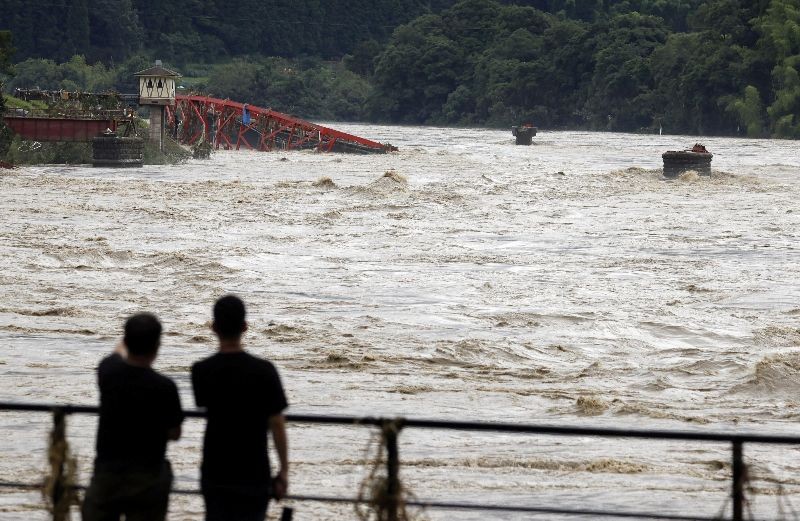People watch the swollen Kuma River after torrential rain in Kuma town, Kumamoto Prefecture, southwestern Japan in this photo taken by Kyodo, on July 6, 2020. Mandatory credit Kyodo/via REUTERS